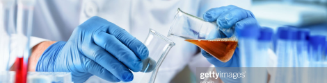 chemist in a lab pouring chemicals